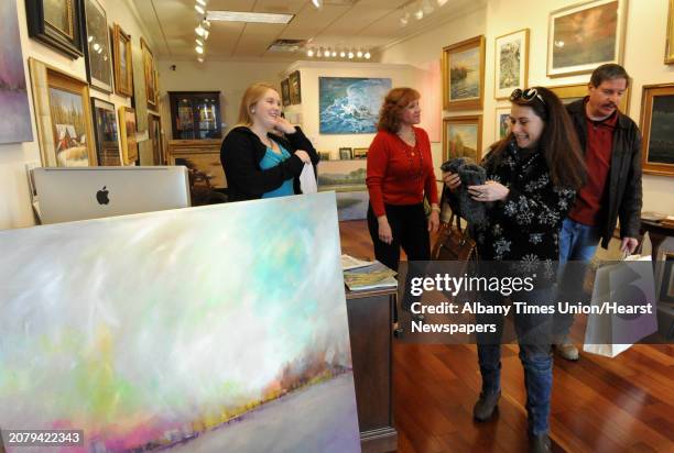 Asher Weiner, right, and his wife Nirit Weiner of Voorheesville purchase art from the Sorelle Gallery, owned by Sandra Pelletier, center, gallery...