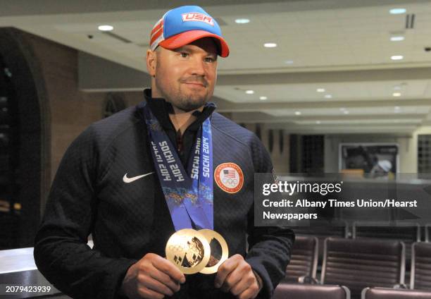 Team U.S.A. Olympic bobsled pilot Steve Holcomb arrives at Albany Airport with medals in hand Tuesday evening, Feb. 25 in Colonie, N.Y. Holcomb...