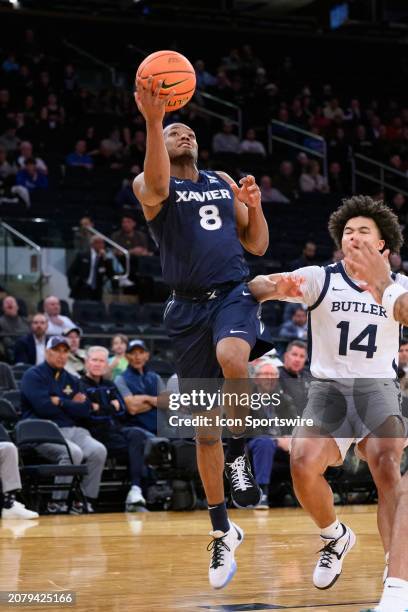 Xavier Musketeers guard Quincy Olivari drives past Butler Bulldogs guard Landon Moore for a layup during the Big East Tournament men's college...