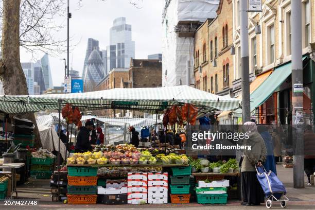 Fruit and vegetable stall on Whitechapel market against a backdrop of skyscrapers in the city of London, UK, on Friday, March 15, 2024. UK headline...