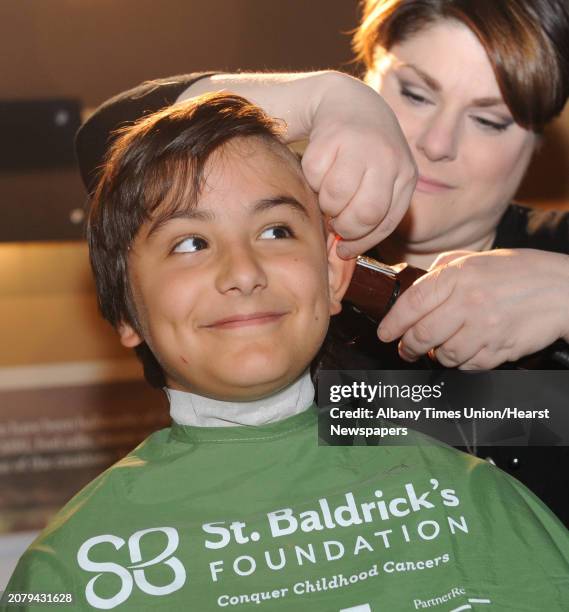 Ten-year-old Tristan Bach of Niskayuna lets go of his locks with a smile as Lauran McDonald runs the clippers during the St. Baldrick's Foundation...