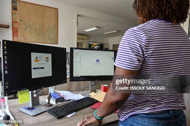 Person stands next to a computer without an internet connection in an office in Abidjan on March 15, 2024 as Ivorian authorities are working to...