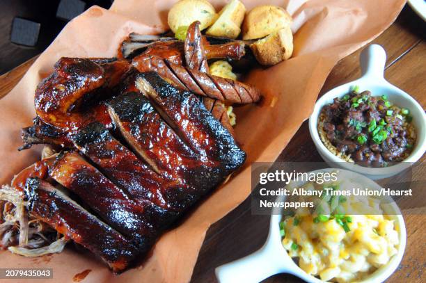 The Pit Master with ribs, smoked pulled pork, brisket, chicken and smoked jalapeno sausage with two sides mac and cheese and rice and beans at the...