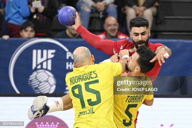 Bahrain's right back Mohamed Ahmed jumps to shoot in spite of Brazil's right back Gustavo Rodrigues and Brazil's left wing Guilherme Torriani during...