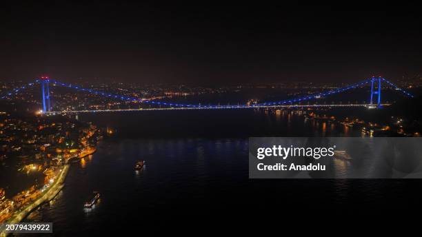 An aerial view of the Fatih Sultan Mehmet Bridge, illuminated with blue lights to raise awareness for colon cancer in Istanbul, Turkiye on March 15,...