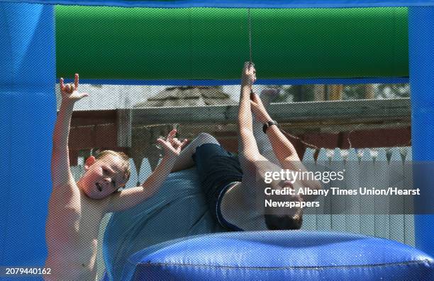 Dusty Decker and Jett Beach, right of Chenanga Forks keep cool in a water filled bounce house during the 2016 Festival of Horsepower at the...
