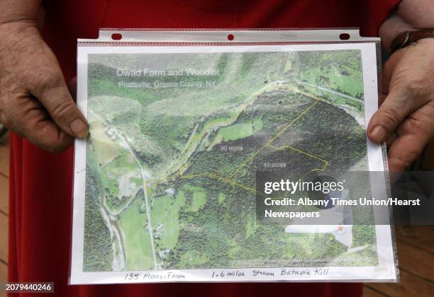 Christine "Ahes" Owad who has lived at her parents' farm for 51 years holds a map of her property on Thursday Aug. 18, 2016 in Prattsville, N.Y. Last...