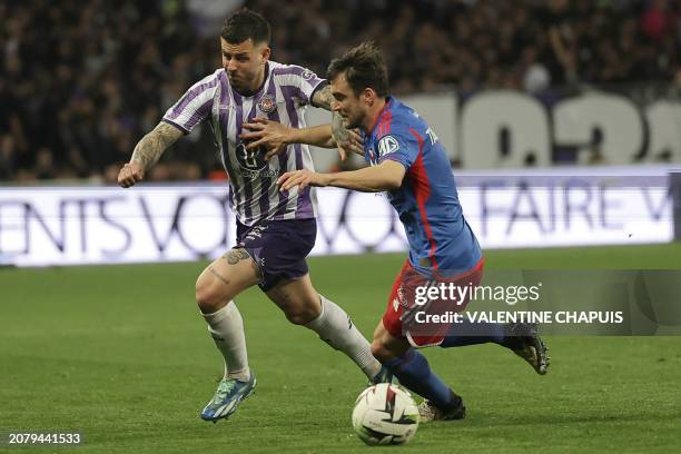 Toulouse's Norwegian midfileder Aron Leonard Donnum fights for the ball with Lyon's Argentinian Italian defender Nicolas Tagliafico during the French...