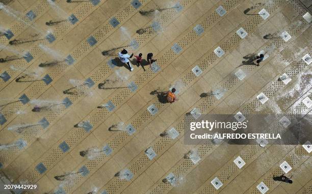 This aerial view shows people cooling down at the fountain of the Monumento a la Revolucion in Mexico City on March 15 as record high temperatures...
