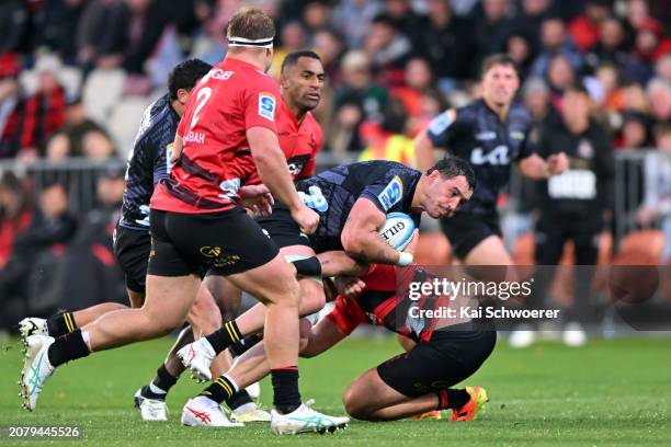 Devan Flanders of the Hurricanes is tackled during the round four Super Rugby Pacific match between the Crusaders and Hurricanes at Apollo Projects...