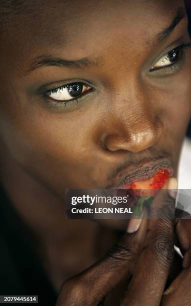 Model eats a strawberry as she has her make-up applied ahead of the Vivienne Westwood show at London Fashion Week, on February 14 2008. London...