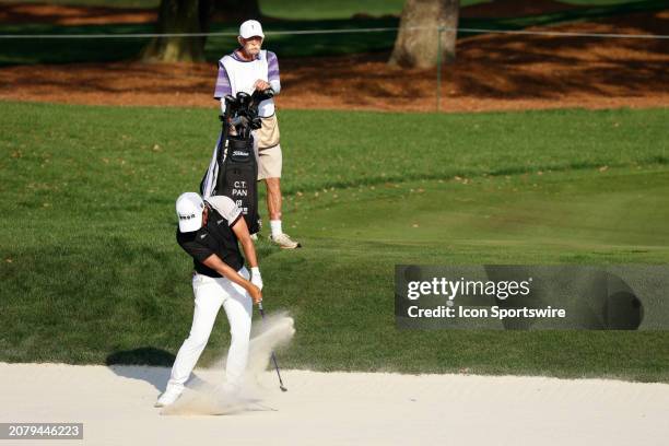 Golfer C.T. Pan plays a shot out of a fairway bunker while his caddie Mike "Fluff" Cowan watches on the 11th hole during The Players Championship on...