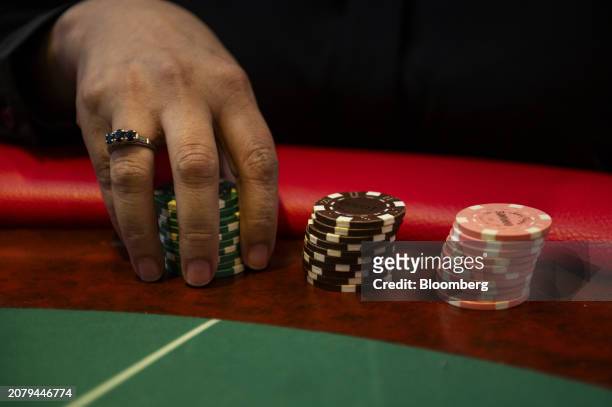 Player holds chips on a Baccarat Super 6 table inside Philippine Amusement and Gaming Corp.'s Casino Filipino Citystate, in Manila, the Philippines,...