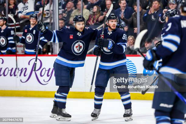 Neal Pionk and Nate Schmidt of the Winnipeg Jets celebrate a second period goal against the Anaheim Ducks at the Canada Life Centre on March 15, 2024...