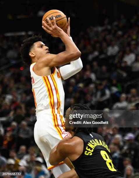 Jalen Johnson of the Atlanta Hawks shoots over Brice Sensabaugh of the Utah Jazz during the first half of a game at Delta Center on March 15, 2024 in...