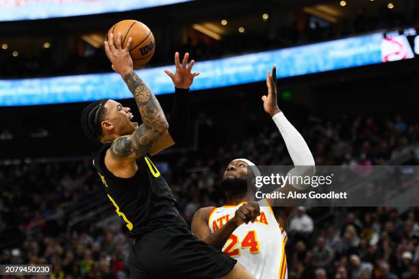 Keyonte George of the Utah Jazz shoots over Bruno Fernando of the Atlanta Hawks during the second half of a game at Delta Center on March 15, 2024 in...