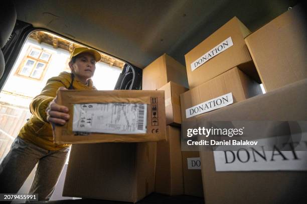 female courier loads donation parcels for delivery. - truck driver pov stock pictures, royalty-free photos & images