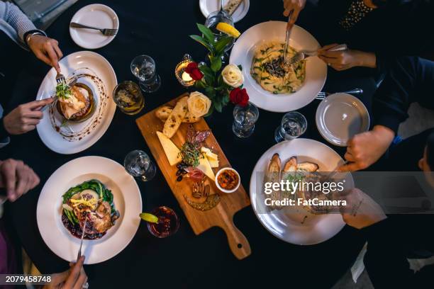 enjoying a meal together - sentarse a comer fotografías e imágenes de stock
