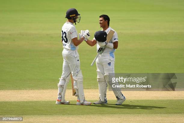 Oliver Davies of New South Wales celebrates reaching his century with Chris Green of New South Wales during the Sheffield Shield match between...