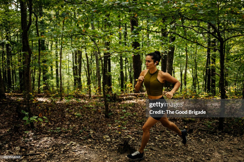 Female athlete running in forest
