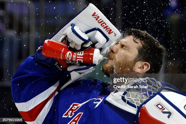 Jonathan Quick of the New York Rangers sprays water during the first period against the New Jersey Devils at Madison Square Garden on March 11, 2024...