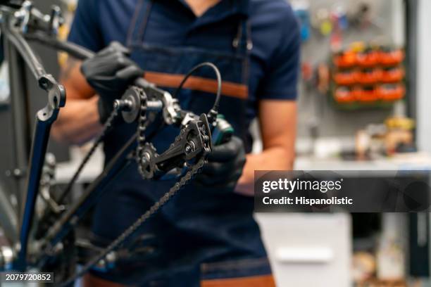 mechanic fixing a bicycle at a repair shop - hispanolistic stockfoto's en -beelden