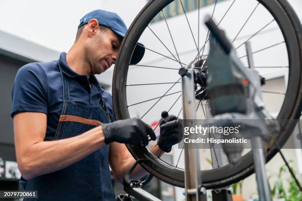 mecánico instalando los frenos de una bicicleta - hispanolistic fotografías e imágenes de stock