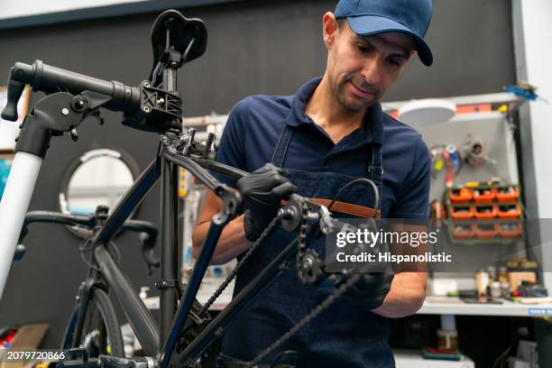 bicycle mechanic fixing a at the repair shop - hispanolistic stockfoto's en -beelden