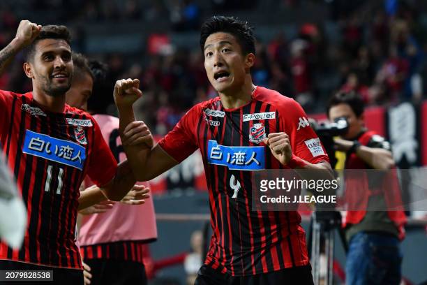 Ken Tokura of Consadole Sapporo celebrates with teammate Jonathan Reis after scoring the team's first goal during the J.League J1 match between...