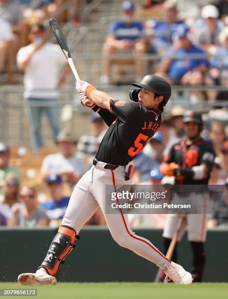 Jung Hoo Lee of the San Francisco Giants bats against the Los Angeles Dodgers during the first inning of the MLB spring game at Camelback Ranch on...