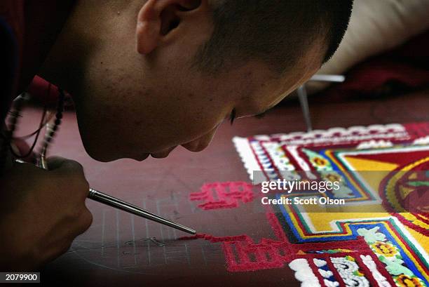 Sonam Tsering, a Tibetan monk from the Lhunpo Monastery in southern India, helps to create a sand Mandela, one piece of sand at a time, at the Field...