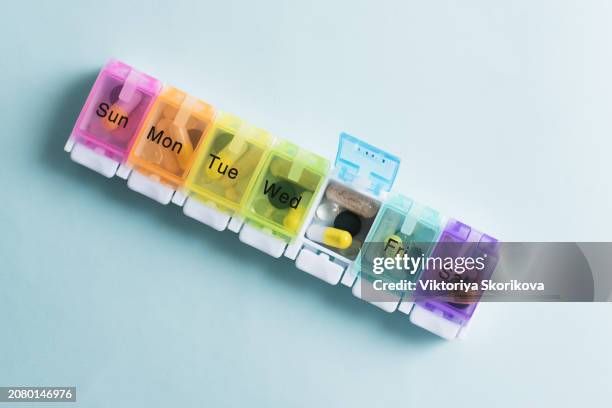 weekly pillbox with medication, conceptual image, horizontal composition - weekly stock pictures, royalty-free photos & images