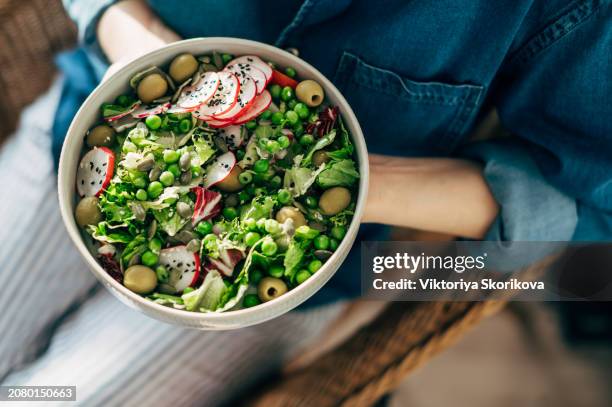 woman hands eating vegan salad of baked vegetables, avocado, tofu and buckwheat buddha bowl, top view. plant based food concept. - arm made of vegetables stock pictures, royalty-free photos & images