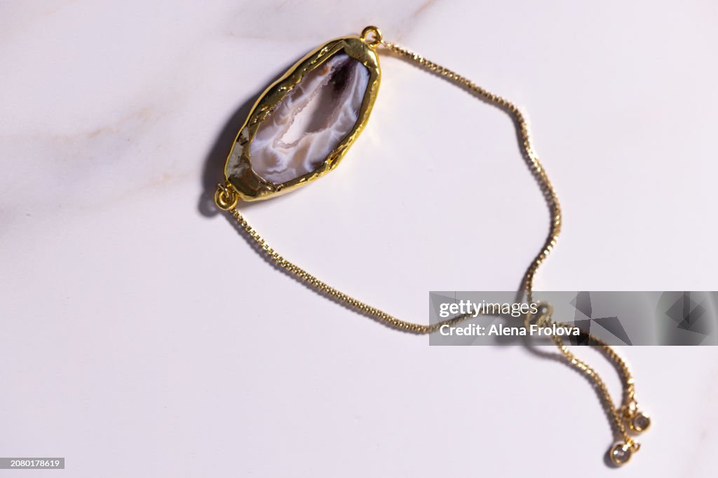 Earrings and bracelet with a stone on a marble background, the concept of natural jewelry, connection with nature