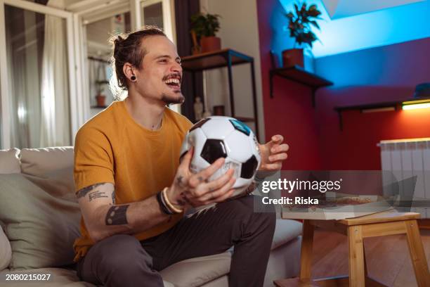 man watching a soccer game at home - championship final round stock pictures, royalty-free photos & images