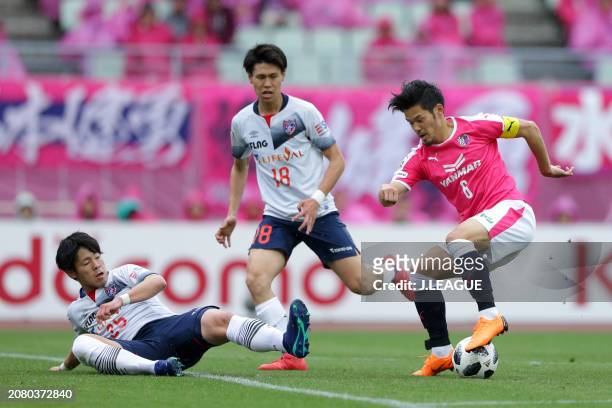 Hotaru Yamaguchi of Cerezo Osaka controls the ball against Kento Hashimoto and Ryoya Ogawa of FC Tokyo during the J.League J1 match between Cerezo...