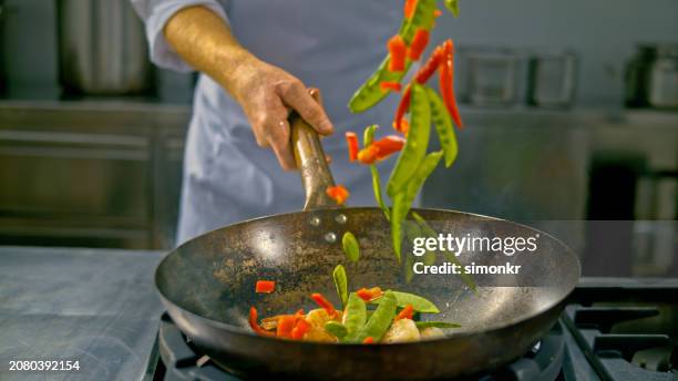 vegetables falling into a heated wok - wok stockfoto's en -beelden