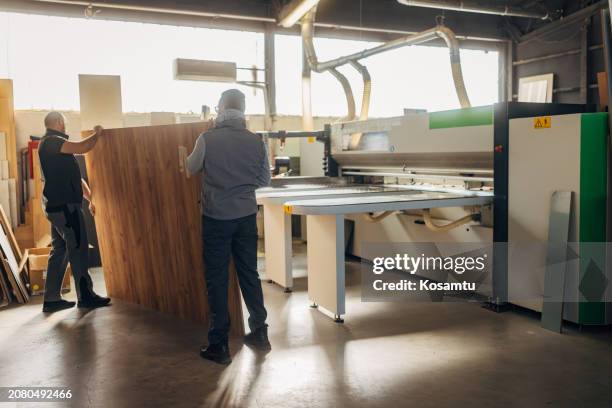 two carpenters work as a team on woodworking and making furniture - wood paneling stock pictures, royalty-free photos & images