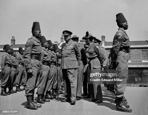 Major General William Alfred Dimoline inspects King's African Rifles on parade at Woolwich, London, UK, 25th May 1957.
