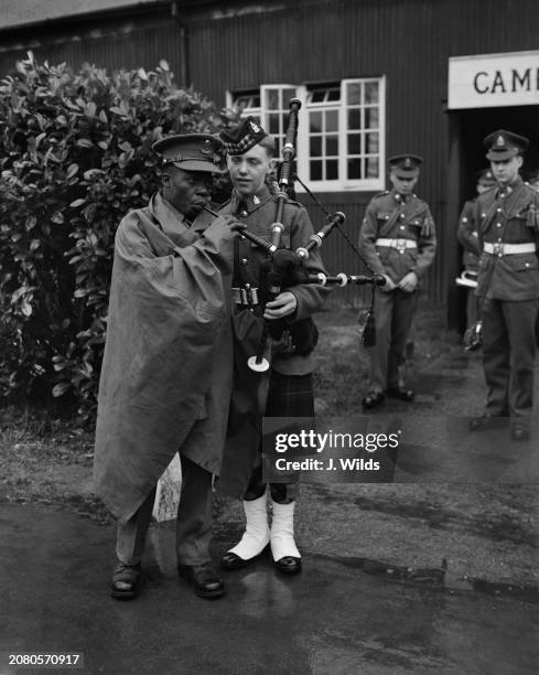 Soldier of the Gold Coast has a go at the pipes, held by A T may of Mansfield, at the Army Apprentices School at Arborfield, UK, 31st January 1956.