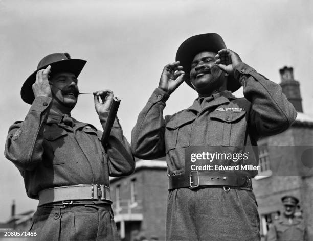 Reginald Caldicott and RSM Bana Maiduguri, both of the Colonial Coronation Nigerian Contingent, check their mustaches at the Royal Artillery Depot in...