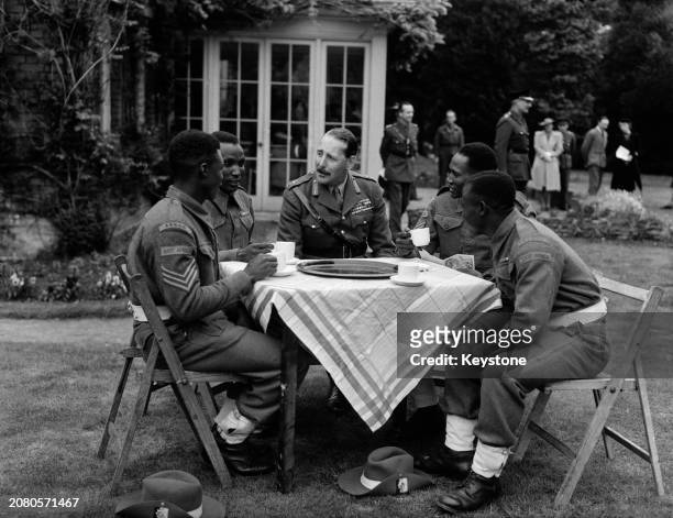 Lieutenant General Oliver Leese chatting to soldiers of the East African Victory Contingent at a tea party in the garden of his residence, UK, June...