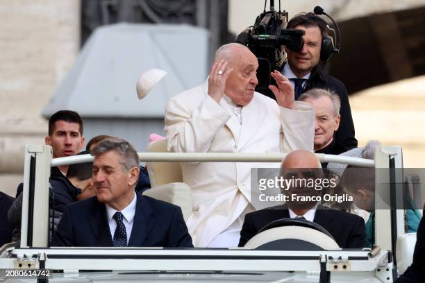 The biretta cup of Pope Francis is blown off his head by a gust of wind as he holds his weekly audience in St. Peter's Square on March 13, 2024 in...