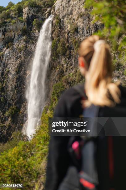 rear view of a woman hiker standing in front of a waterfall, alpes-maritimes, france - air france stock pictures, royalty-free photos & images