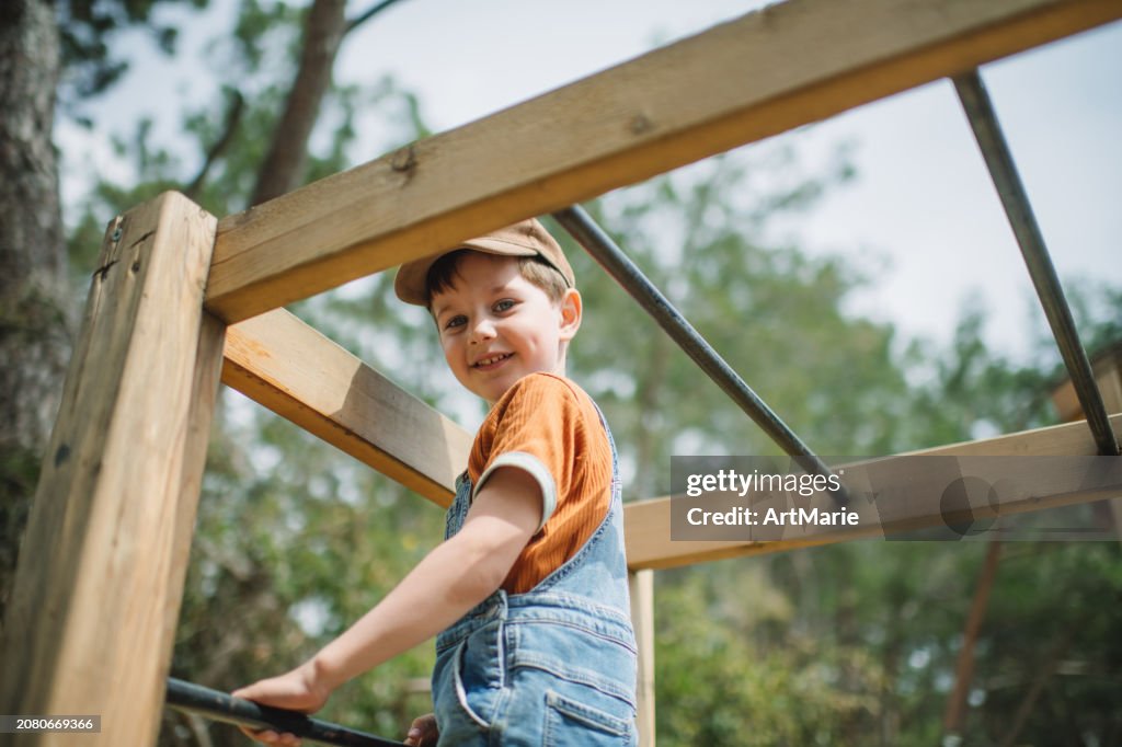 Cute child playing at playground in summer park