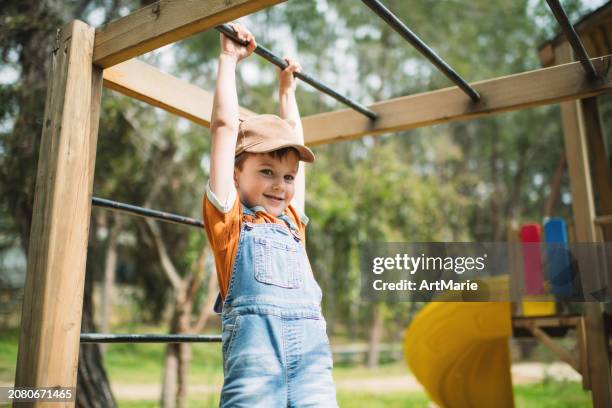 bambino sveglio che gioca al parco giochi nel parco estivo - solo bambini maschi foto e immagini stock