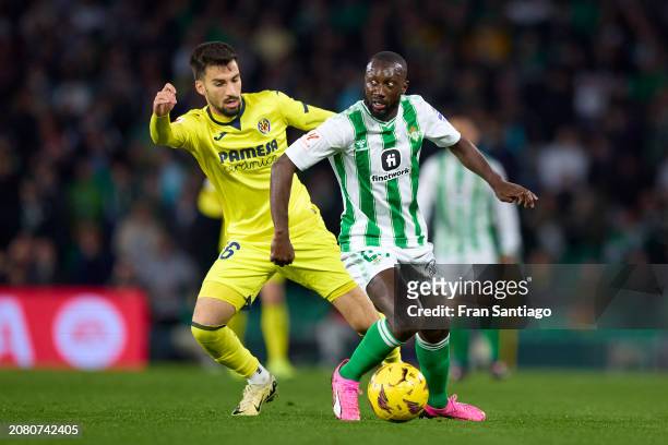 Youssouf Sabaly of Real Betis is challenged by Alex Baena of Villarreal CF during the LaLiga EA Sports match between Real Betis and Villarreal CF at...
