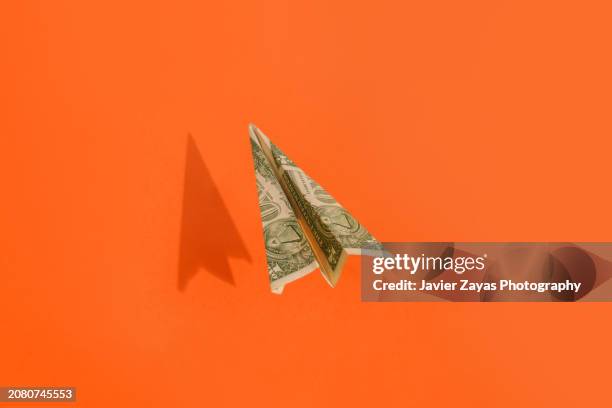 paper airplane making of dollar money flying on yellow background - billete de un dólar estadounidense fotografías e imágenes de stock