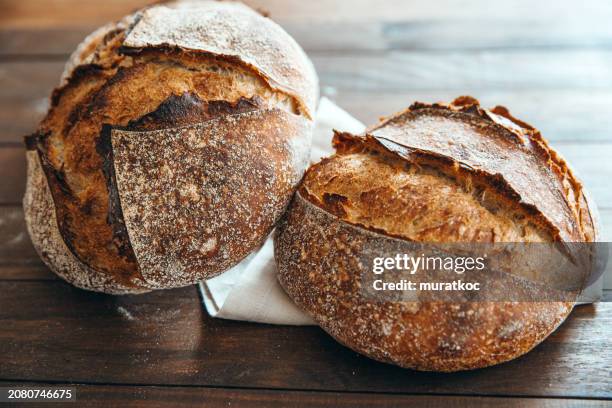 freshly baked homemade artisan sourdough whole wheat bread - sourdough bread stock pictures, royalty-free photos & images