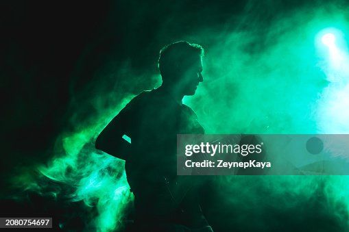Silhouette of a guitarist on stage light and smoke effects. Silhouette of a guitarist on stage light and smoke effects.
